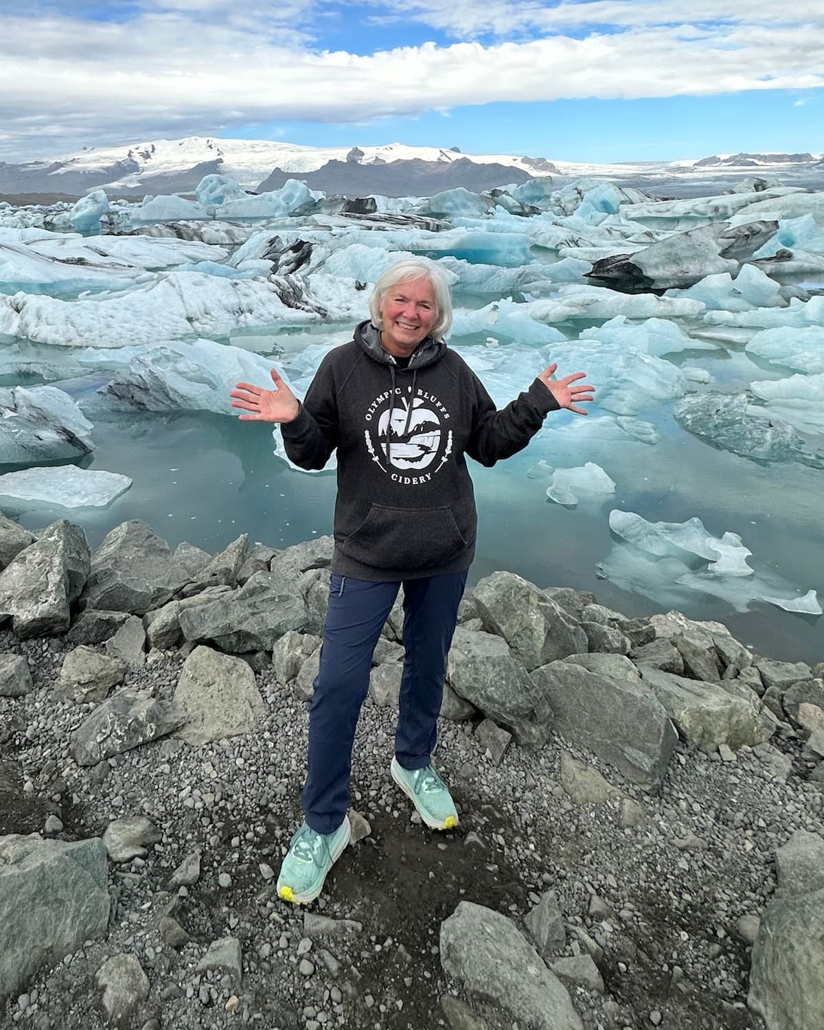 Gail Harper in an Olympic Bluffs Cidery hoodie at a glacier lagoon in Iceland